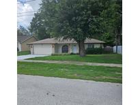 Charming single story home with an attached garage and mature trees in the front yard at 204 Madison St, Minneola, FL 34715
