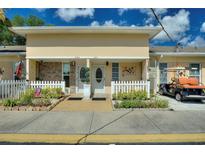 Charming townhome with a well-maintained lawn, a white picket fence, and a private golf cart at 4711 Club Cir, Lakeshore, FL 33854