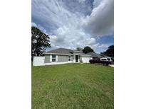 Charming single-story home featuring a well-manicured lawn and a side-entry two-car garage at 10090 Se 67Th Ter, Belleview, FL 34420