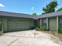 Single story home featuring attached garage, front yard and stone facade near the front door at 3300 Glen Village Ct, Orlando, FL 32822