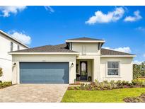 Charming single-story home featuring a blue garage door, landscaped front yard, and a welcoming entrance at 5793 Timber Meadow Way, St Cloud, FL 34771