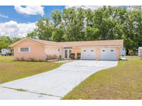 Charming single-story home features an attached two-car garage and long driveway with ample parking at 21078 Sw Honeysuckle St, Dunnellon, FL 34431