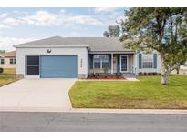 Charming single-story home featuring a blue garage door and front door, nicely landscaped front yard, and stone accents at 1074 Canary S Cir, Lakeland, FL 33809