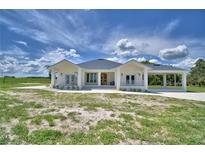 Bright, airy home featuring a covered front porch, modern design, and ample space for outdoor enjoyment at 359 Terminal Ave, Polk City, FL 33868