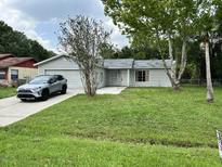 Charming single-story home featuring a well-maintained lawn and a paved driveway at 299 Cobalt Dr, Kissimmee, FL 34758