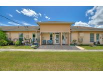 Charming duplex featuring a well-manicured lawn and cozy front porch seating at 523 Club Cir, Lakeshore, FL 33854