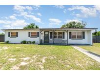 Charming single-story home featuring a cozy front porch and a well-maintained lawn at 811 Casselberry Dr, Lake Wales, FL 33853