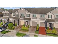 Townhome exteriors featuring neutral paint, private entrances and driveways with manicured landscaping at 1183 Honey Blossom Dr, Orlando, FL 32824