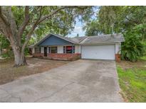 Charming single-story home with a driveway and a two-car garage and mature trees at 1440 12Th St, Clermont, FL 34711