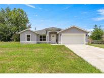 Charming single-story home with a well-maintained lawn and attached two-car garage at 231 Marion Oaks Trl, Ocala, FL 34473