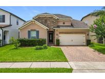 Charming single-Gathering home featuring a stone accent wall, brick driveway, manicured lawn, and a two-car garage at 1138 Fountain Coin Loop, Orlando, FL 32828