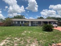 Charming single-story home with gray brick exterior, well-maintained lawn, and a covered carport at 119 Allen Ave, Winter Haven, FL 33880
