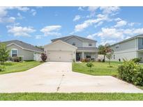 Charming two-story home with a manicured lawn, a driveway and lovely landscaping at 1518 Louise Ave, Auburndale, FL 33823