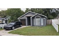 Charming single-story home with a well-maintained lawn and a modern grey facade at 528 Winding Oak Ln, Longwood, FL 32750