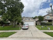 Charming two-story home featuring a two-car garage, well-maintained lawn, and mature shade tree at 606 Carrigan Woods Trl, Oviedo, FL 32765