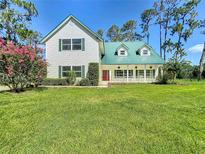Charming two-story home with green metal roof and landscaped yard at 10222 Rockridge Rd, Lakeland, FL 33810