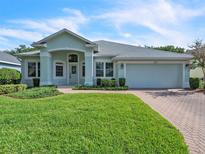 Charming one-story home with a well-manicured lawn and a brick driveway, featuring a two-car garage and inviting curb appeal at 2925 Dayton Dr, Winter Haven, FL 33884