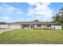 Charming single-story home with a manicured lawn, fresh flowers, and a classic American flag at 5324 Messina, Lakeland, FL 33813
