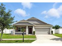 Charming single-story home with well-maintained lawn and two-car garage at 303 Briarbrook Ln, Haines City, FL 33844