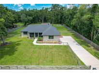 Beautiful single-story home on a large lot featuring a well-manicured lawn and long driveway at 5080 Maple Dr, Lakeland, FL 33810