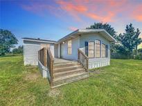 Charming single-story home with a wooden porch and a well-maintained lawn at 5268 Rock Dove Loop, Lakeland, FL 33810
