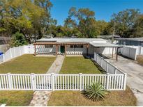 Charming home with a well-manicured lawn, white picket fence, and inviting walkway at 1616 Huntington St, Lakeland, FL 33801