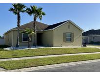 Charming home featuring palm trees, a well-manicured lawn, and neutral-toned exterior at 2864 Running Brook Cir, Kissimmee, FL 34744
