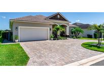 Beautiful single-story home featuring a manicured lawn, a brick driveway, and a two-car garage at 3249 Pearly Dr, Lakeland, FL 33812
