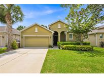 Charming single-story home featuring lush green lawn, a two car garage, and a well manicured front yard at 890 Marisa Ln, Kissimmee, FL 34744