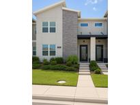Modern two-story townhome featuring stone accents, well-kept landscaping and a welcoming front entrance at 1052 Leader St, Davenport, FL 33896