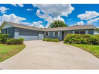 Charming single-story home featuring a gray brick exterior, attached garage, and well-maintained landscaping at 1327 Glenview Ln, Lakeland, FL 33813