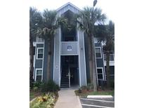 Exterior view of a multi-story condo building with palm trees and visible unit access at 709 Secret Harbor Ln # 313, Lake Mary, FL 32746