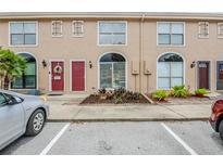 Charming townhome featuring a red front door, landscaped garden, and convenient parking space for residents and visitors at 609 Casa Park N Ct, Winter Springs, FL 32708