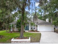 Charming single-story home featuring a two-car garage, manicured lawn, and mature landscaping at 116 Winding Oaks Ln, Oviedo, FL 32765