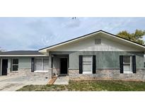 Charming home featuring a stone accent facade, black shutters, and a modern black door at 1420 Wood Ave, Haines City, FL 33844