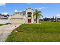 Spacious two-story home with a red front door, two-car garage, and a well-maintained lawn at 811 Abbeville Ct, Kissimmee, FL 34759