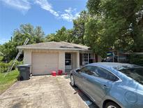 Quaint single-story home with a front lawn, driveway, and an attached garage, under a blue sky with light clouds at 2656 Williston Dr, Lakeland, FL 33801