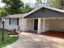Charming one-story brick home with a covered carport, landscaped yard, and a welcoming front entrance at 309 Sunnyside Ln, Debary, FL 32713