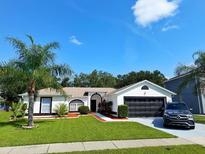 Charming single-story home featuring a well-manicured lawn, dark shutters, and a black two-car garage door at 2526 Sage Dr, Kissimmee, FL 34758