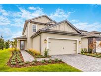 Beautiful two-story home featuring a two-car garage, manicured lawn, and charming stone walkway at 7728 Somersworth Dr, Kissimmee, FL 34747