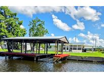 Waterfront home featuring a private covered boat dock with a lift for easy water access at 1628 Paradise Ln, Astor, FL 32102