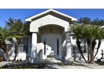 House exterior featuring a white door, arched entryway, and palm trees at 1562 Pendleton St, Deltona, FL 32725