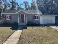 Charming house with red accents and a well-maintained lawn at 612 E Plymouth Ave, Deland, FL 32724