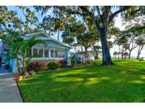 Charming bungalow with a lush front yard, mature trees, and patio at 111 Fleming Ave, Port Orange, FL 32127