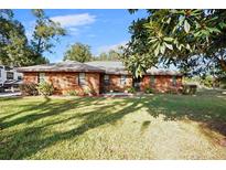 Charming brick home featuring a lush front lawn and well-maintained landscaping at 1195 Glen Royal Ter, Deland, FL 32720