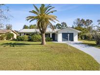 Charming home featuring a well-manicured lawn, a palm tree, and a white brick facade at 1437 Colin Kelly Ave, Daytona Beach, FL 32124