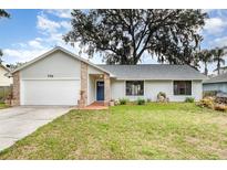 Charming single-story home featuring a well-manicured lawn and an attached two-car garage at 779 Victoria E Cir, Ormond Beach, FL 32174