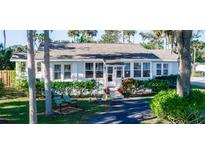 Charming single story home with light blue exterior paint, manicured landscaping, and inviting front porch at 5178 Riverside Dr, Port Orange, FL 32127