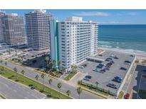 An aerial view of a beachfront condo building, palm trees, and an ocean view at 2800 N Atlantic Ave # 212, Daytona Beach, FL 32118
