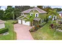 Two-story home featuring lush landscaping, a three car garage and large driveway at 732 Wildmere Village Cv, Longwood, FL 32750